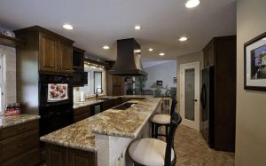 Luxurious kitchen with barstools, dark brown cabinets, and a raised bar countertop