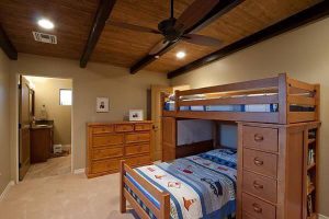 Newly built bedroom with carpet, bunk beds, and wooden ceiling.