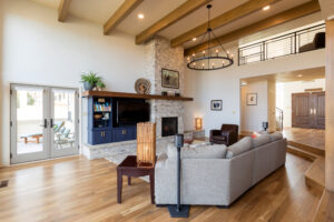 Warm living room with wooden floor, fireplace, and French doors leading to patio area.