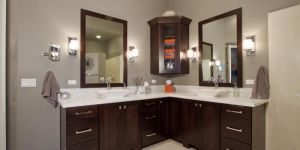 Newly remodeled bathroom featuring wooden cabinets, marble countertops, and large vanity mirrors