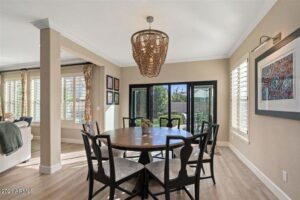 Modern kitchen with wood flooring, round dining table, and an elaborate chandelier hanging from the ceiling.