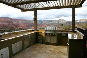 Custom outdoor kitchen with overhead louvers and a magnificent view of mountains.